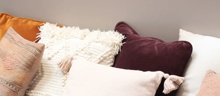Soft cushions and a woven throw on a sofa