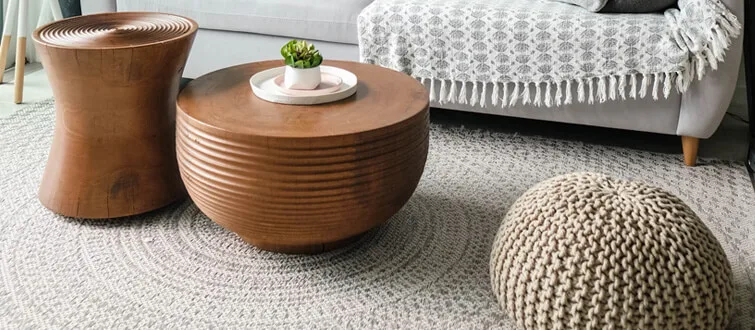 Woven stools and round side tables beside a sofa