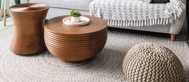Woven stools and round side tables beside a sofa