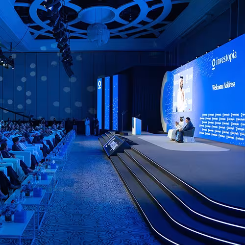 Blue conference stage with wide steps and display panels